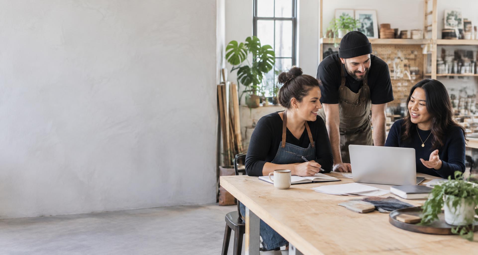 Small business owners collaborating around a worktable